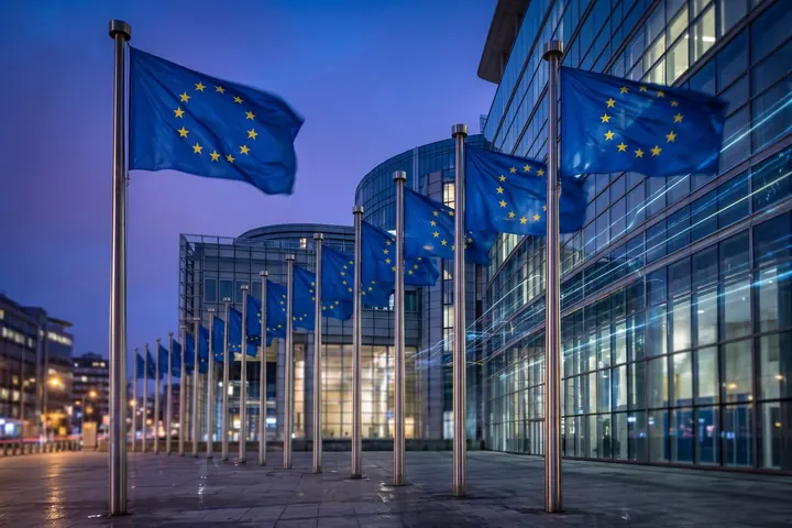 Banderas de la Unión Europea frente a un edificio de vidrio en Bruselas