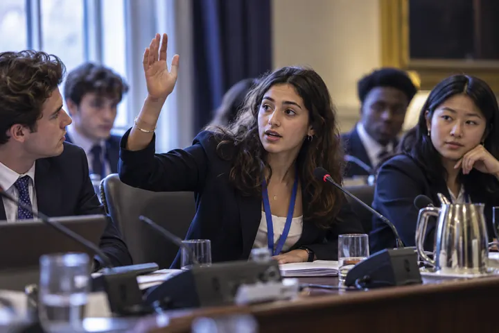 Jóvenes delegados debatiendo con micrófonos de mesa