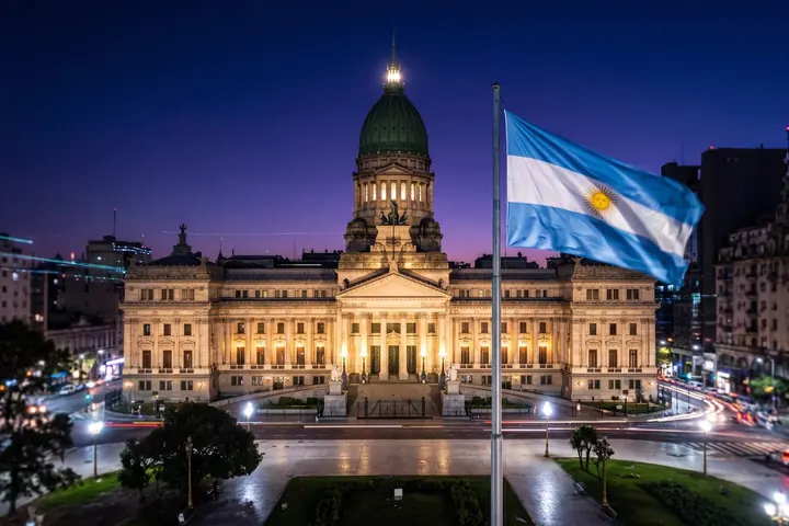 Palacio del Congreso de la Nación Argentina de noche, con la bandera argentina