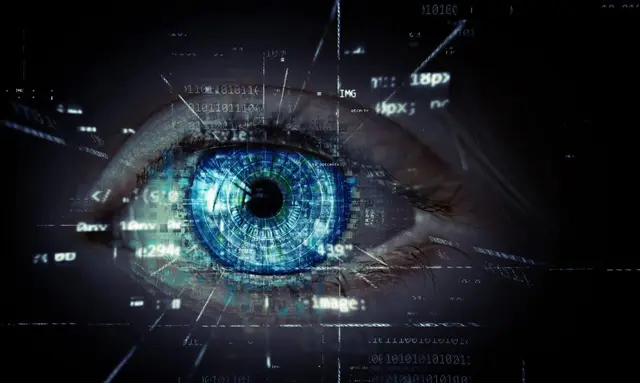 Ojo humano de iris azul con líneas de código y símbolos digitales superpuestos sobre un fondo oscuro