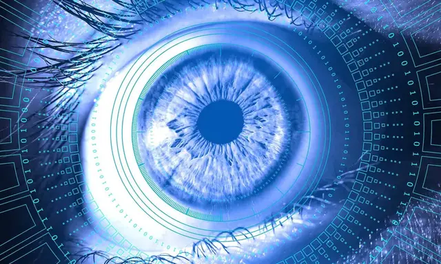 Primer plano de un ojo azul rodeado de círculos concéntricos y dígitos binarios, que sugiere la visión de una máquina