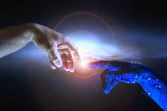 Una mano humana y una mano robótica azul con circuitos acercan los dedos, con un destello de luz entre ambas sobre un fondo oscuro