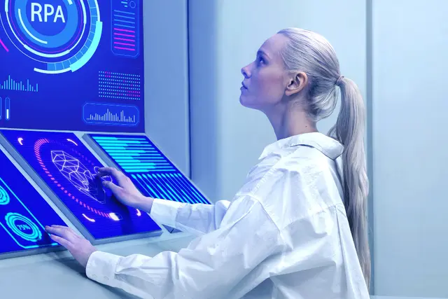 Mujer de bata blanca frente a pantallas táctiles con indicadores azules y la sigla RPA, en un laboratorio de aspecto futurista.