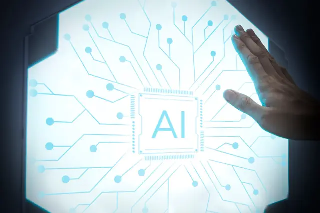 Mano apoyada sobre un panel luminoso hexagonal con un chip central marcado AI y trazos de circuito azul.