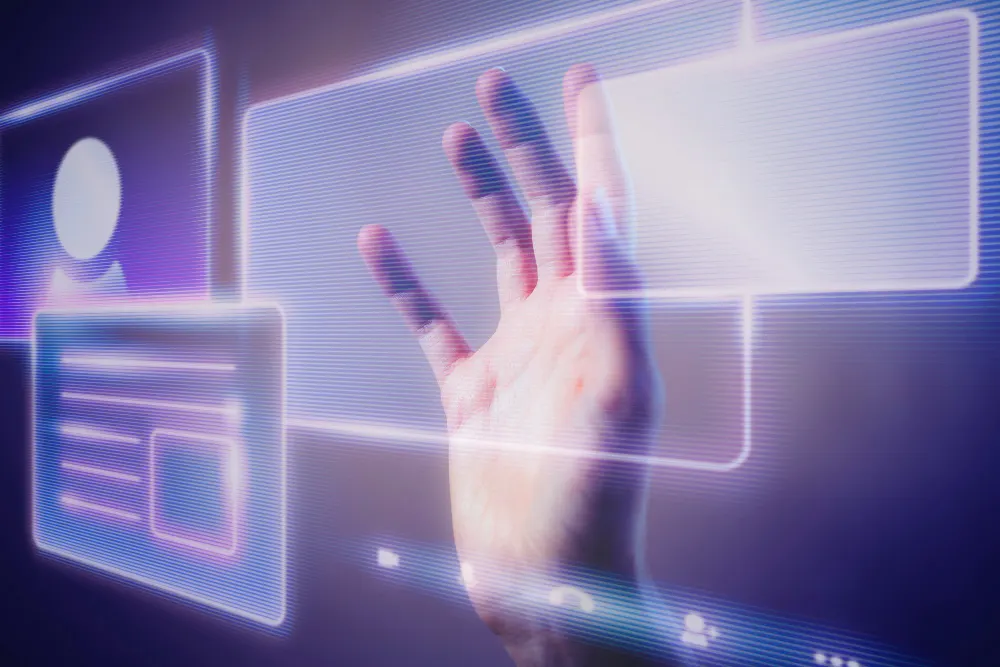 Mano que toca paneles de interfaz translúcidos con luz violeta, imagen de la interacción entre personas y sistemas inteligentes.