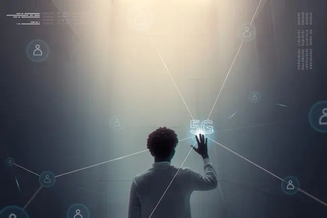 Persona de espaldas que toca con la mano un nodo luminoso con la etiqueta 5G, entre líneas de red e iconos de usuarios