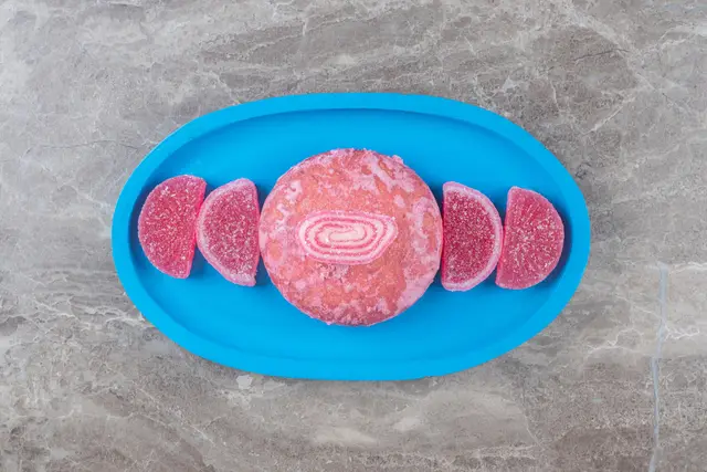 Porciones de carne cultivada de color rosado en una bandeja azul sobre una superficie de mármol gris