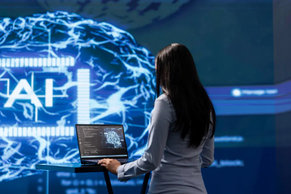 Mujer frente a una pantalla con un cerebro digital y las letras AI, con un portátil en un atril
