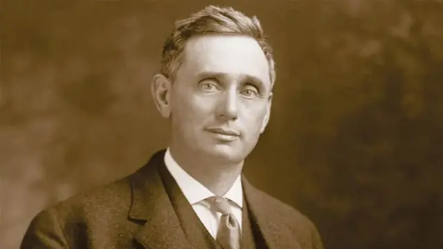 Retrato en sepia de un hombre de cabello corto con traje oscuro, camisa blanca y corbata, imagen del juez Louis Brandeis