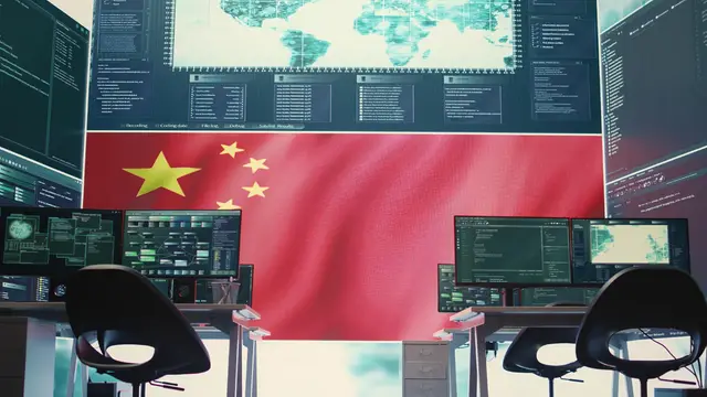 Sala de control con sillas vacías, pantallas con mapas y datos y una gran bandera de China de fondo