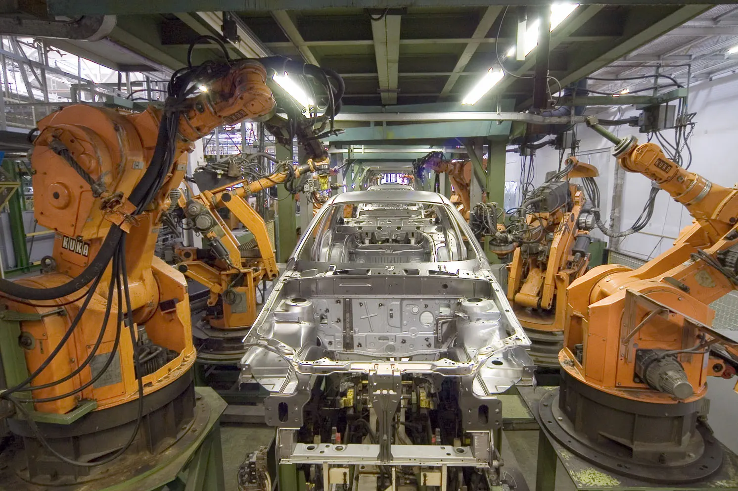 Robots industriales KUKA trabajando en una línea de fabricación automotriz
