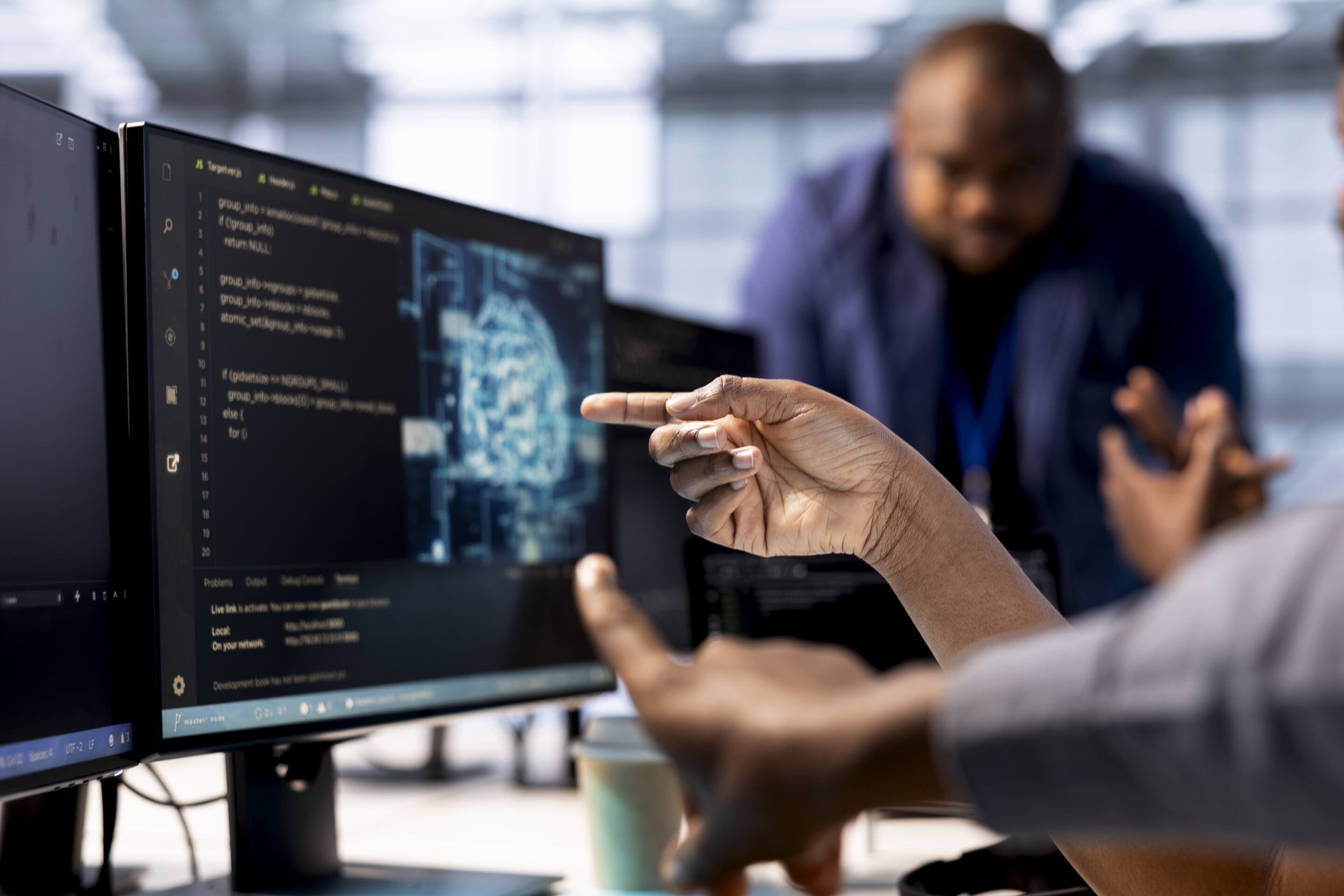 Close up of data center worker pointing finger to AI tech on PC screen